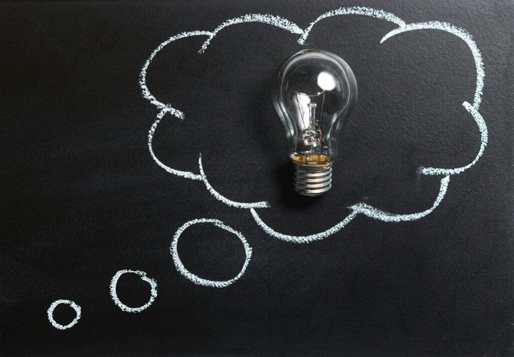 Light bulb inside chalk thought bubble on blackboard representing innovative web accessibility ideas and solutions