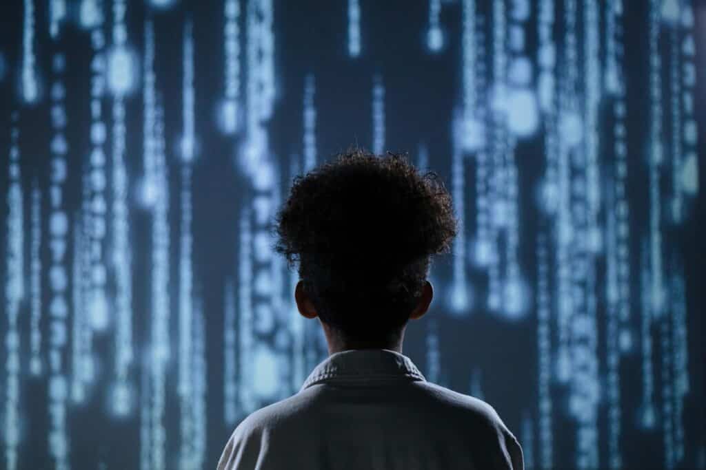Developer silhouette standing before digital code matrix representing human expertise in web development