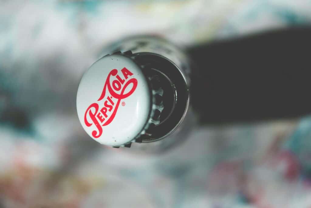 Retro Pepsi Cola bottle against a vibrant blue background, showcasing classic branding and design