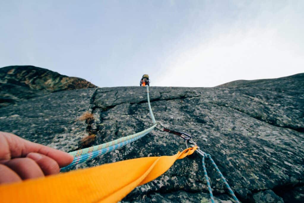 Rock climber using safety rope demonstrating trust and security in challenging situations
